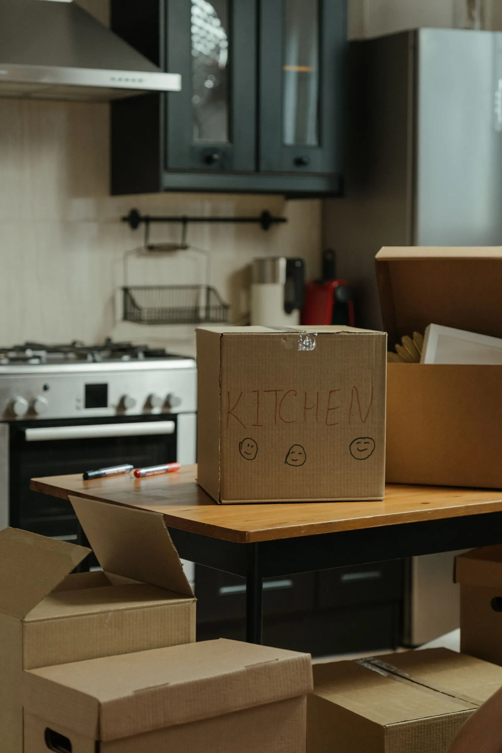 Packed moving boxes labelled kitchen on a counter, ready for a move