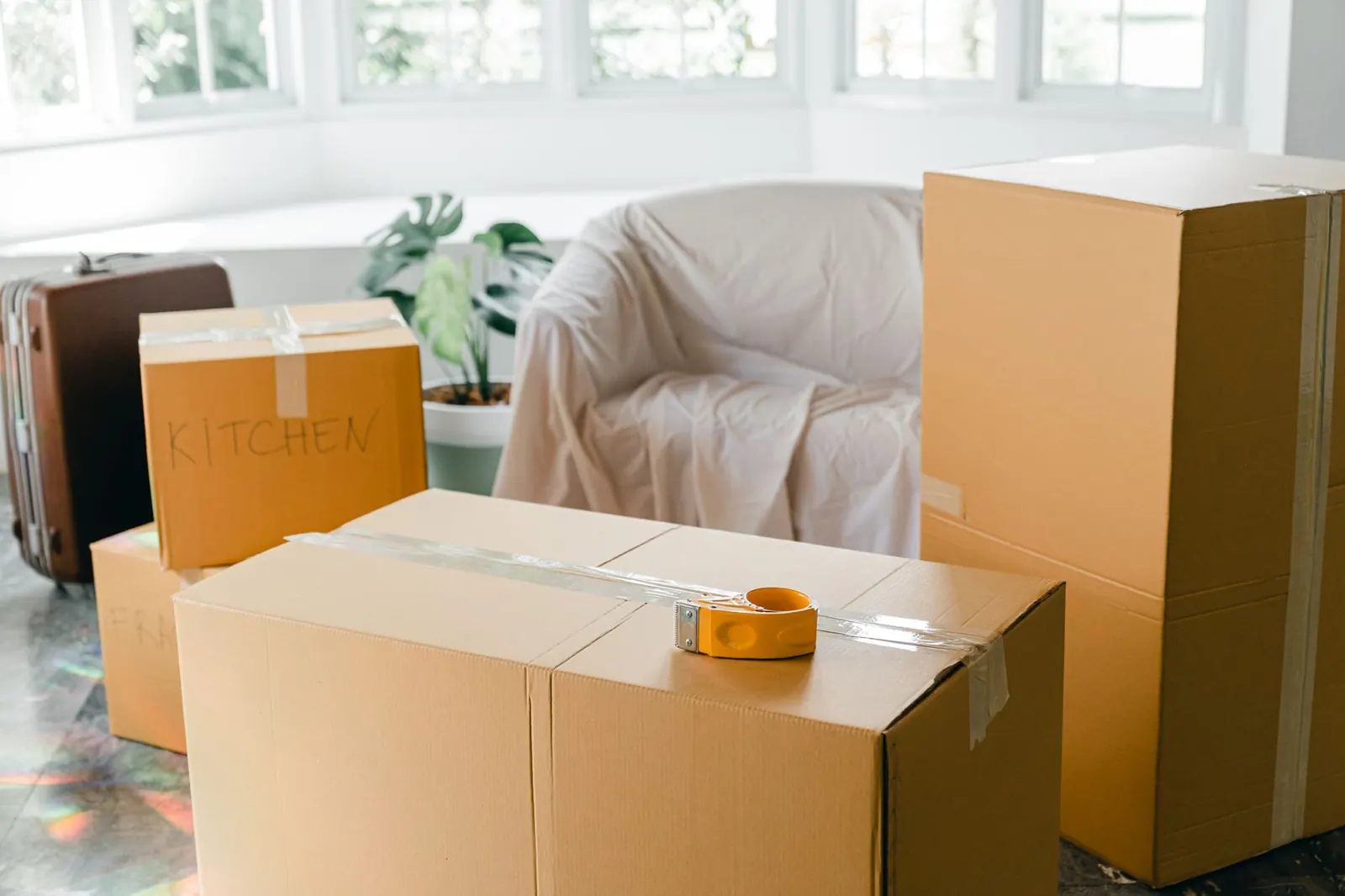 Packed moving boxes in a bright, empty room